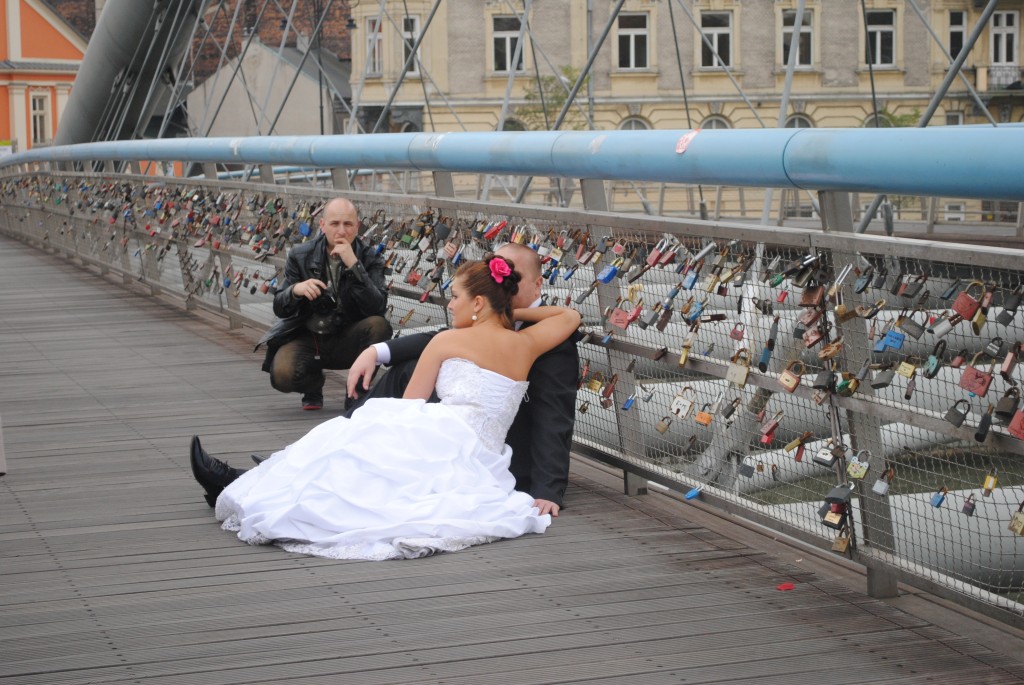 Bride and groom taking pictures on the Lovers Bridge.