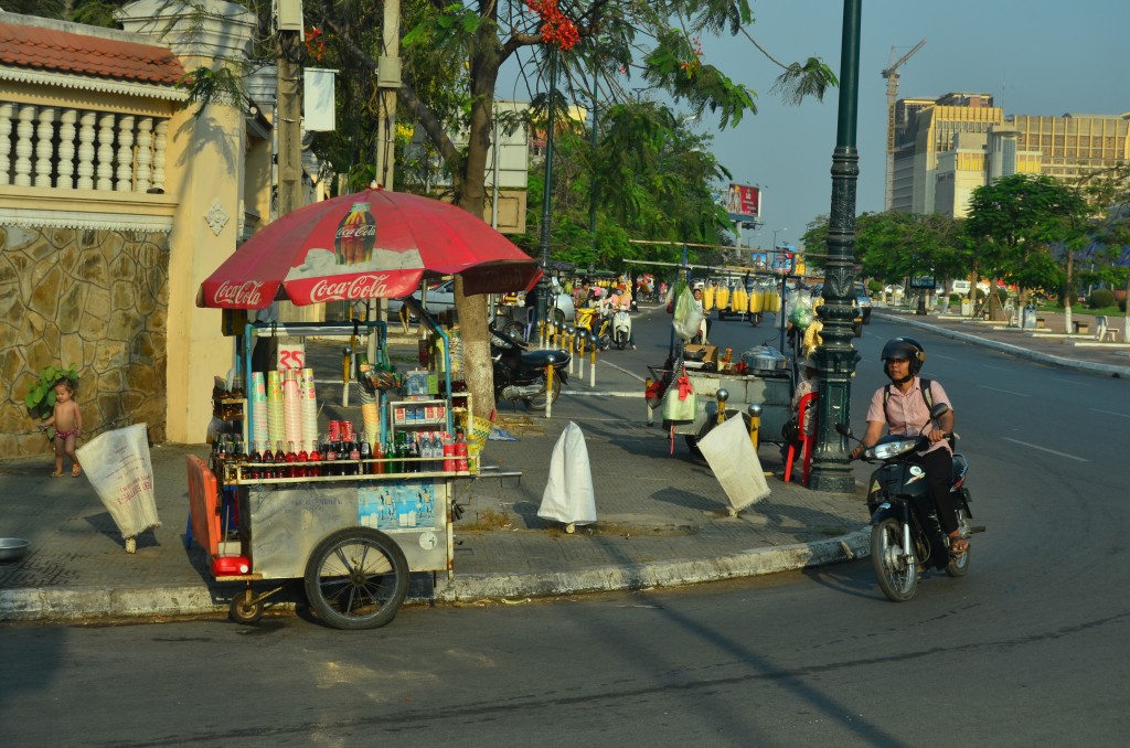 Naked baby, street vendor, motorbike, and a construction crane. A typical scene in Phnom Penh.